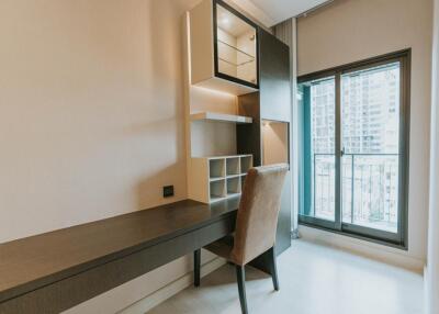 Work desk area with chair and shelves near window