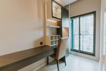 Work desk area with chair and shelves near window