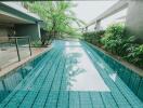 Outdoor swimming pool next to greenery