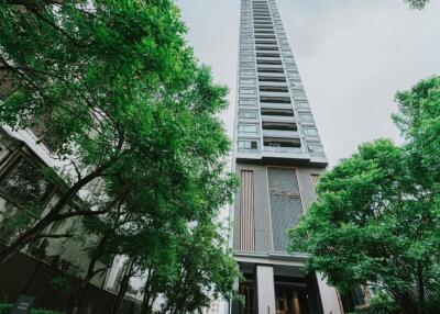 High-rise apartment building exterior with trees