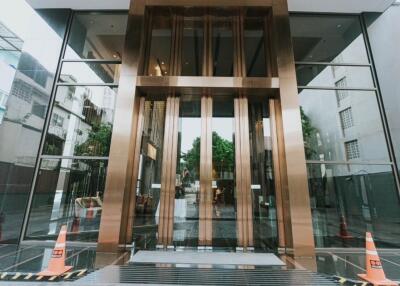 Entrance of a modern building with glass walls and golden accents