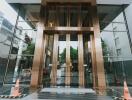 Entrance of a modern building with glass walls and golden accents