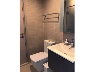 Modern bathroom with sink, toilet, and mirror