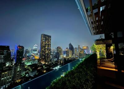 Night view of a city skyline from a balcony