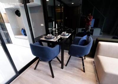 Modern dining area with glass table and two blue chairs