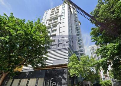 Exterior view of a high-rise residential building surrounded by trees