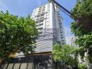 Exterior view of a high-rise residential building surrounded by trees