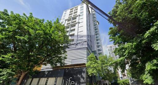 Exterior view of a high-rise residential building surrounded by trees