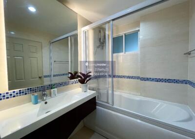 Modern bathroom with large mirrors, bathtub, and sink