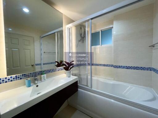 Modern bathroom with large mirrors, bathtub, and sink