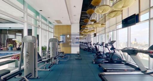 Fully equipped gym with modern exercise machines and large windows