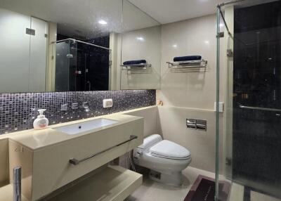 Modern bathroom with glass shower, large mirror, and vanity