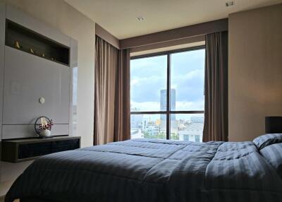 Spacious bedroom with a large window offering a city view