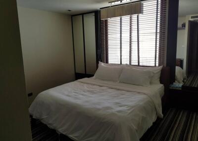 Well-lit bedroom with a bed and large window with blinds