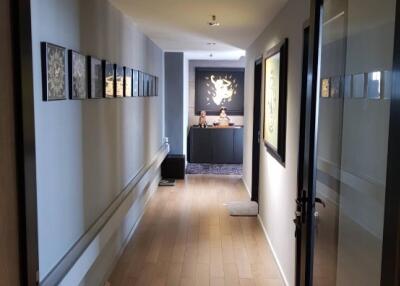 A modern corridor with wooden flooring and artwork on the walls