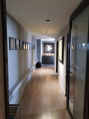 A modern corridor with wooden flooring and artwork on the walls