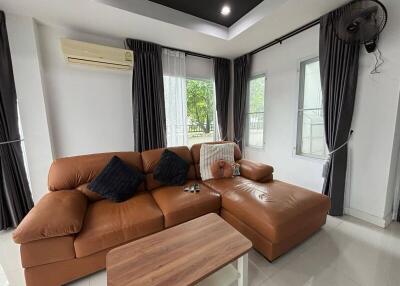 Living room with brown leather sectional sofa and wooden coffee table