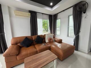 Living room with brown leather sectional sofa and wooden coffee table