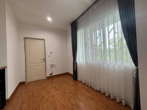 Empty room with wooden flooring and large window