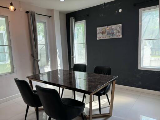 Modern dining area with black marble table and four chairs