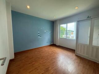 Empty bedroom with wooden floor and decorative blue wall