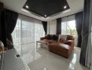 Modern living room with a large brown sofa and panoramic windows