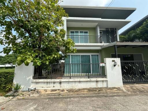 Front view of a modern two-story house with a balcony and gated entrance