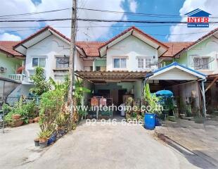 Front view of residential houses with driveways and plants