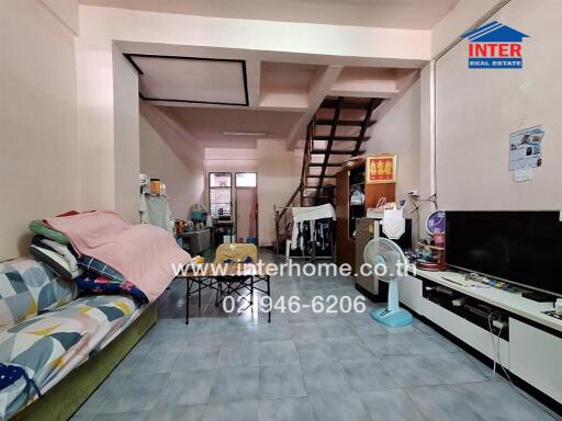 A spacious living room with furniture and a staircase