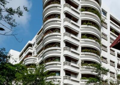 Exterior view of a multi-story residential building with curved balconies