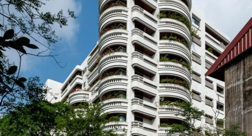 Exterior view of a multi-story residential building with curved balconies