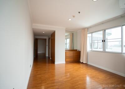 Spacious well-lit bedroom with wooden flooring