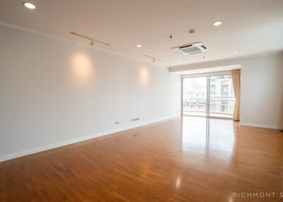 Spacious and well-lit living room with wooden flooring and large windows