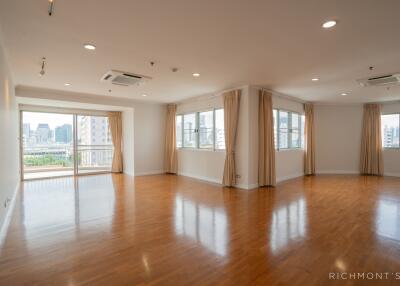 Spacious living room with large windows and wooden flooring