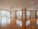 Spacious living room with large windows and wooden flooring