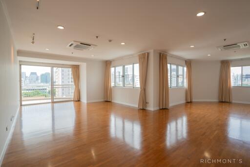 Spacious living room with large windows and wooden flooring