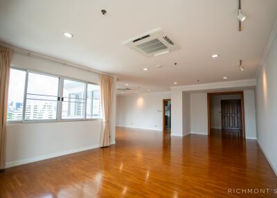 Spacious living area with wooden flooring and large windows