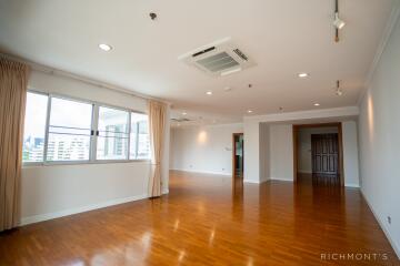 Spacious living area with wooden flooring and large windows