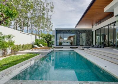 Modern pool area with lounge chairs and contemporary house