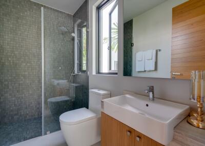 Modern bathroom with glass shower enclosure, large window, and wooden elements