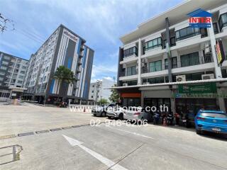 Exterior view of multi-story residential and commercial buildings with parking area