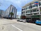 Exterior view of multi-story residential and commercial buildings with parking area