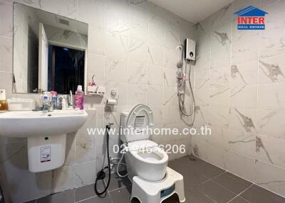 Spacious bathroom with sink, toilet, shower, and wall-mounted water heater