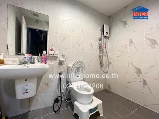 Spacious bathroom with sink, toilet, shower, and wall-mounted water heater