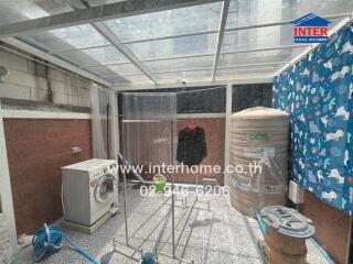 outdoor laundry area with washing machine and water tank