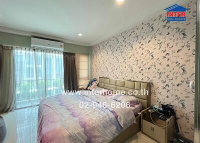 Bedroom with large window, bed, and air conditioning unit