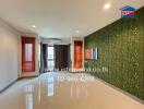 Spacious living room with large windows, modern lighting, and a nature-themed accent wall