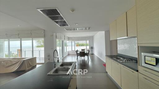 Spacious modern kitchen and living area with large windows and dining space