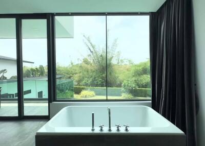 Modern bathroom with large window and standalone tub