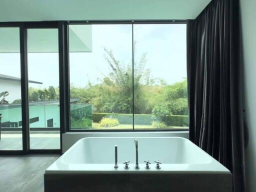 Modern bathroom with large window and standalone tub